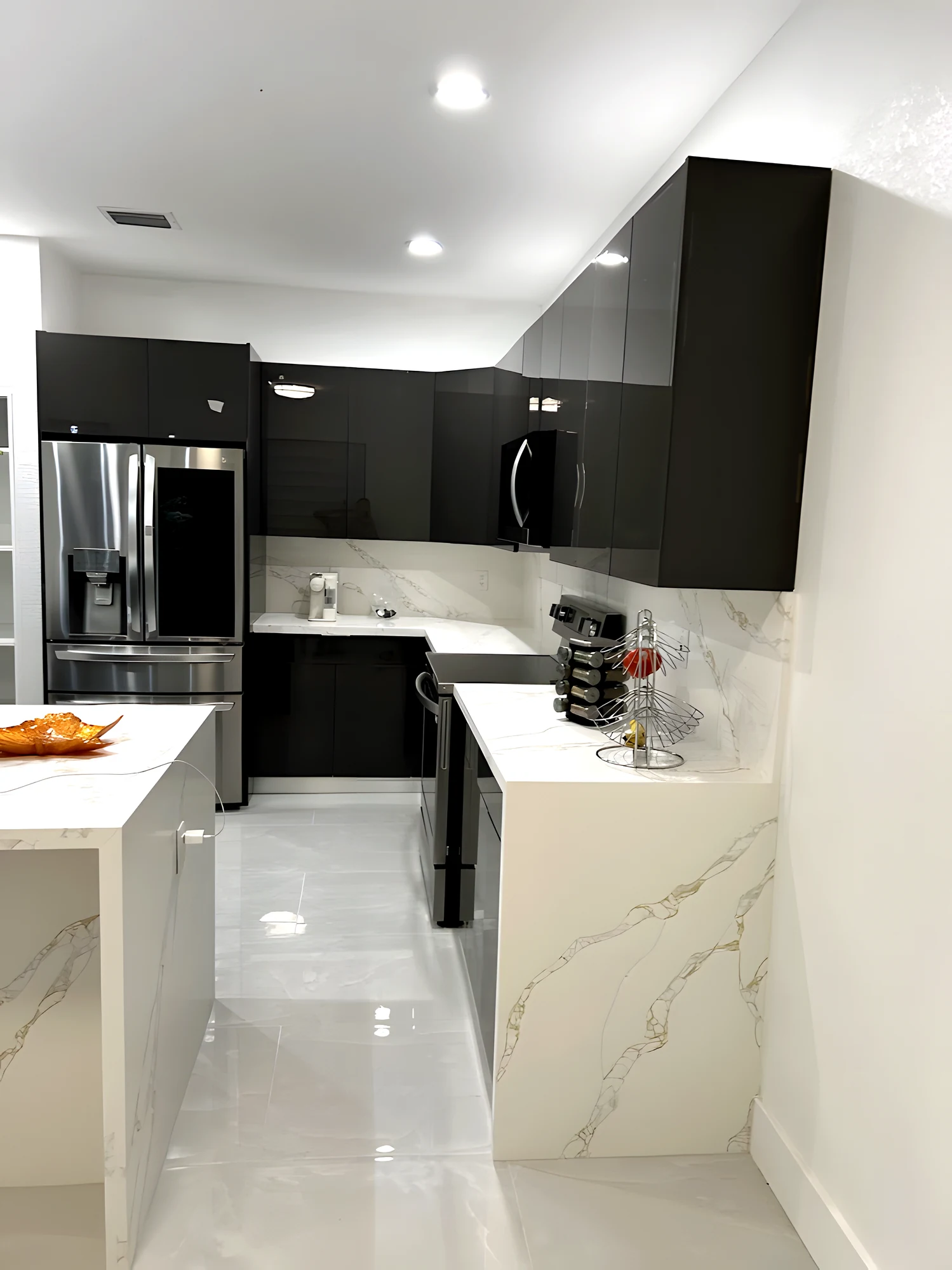 Vista de la cocina desde el pasillo: gabinetes grafito, backsplash de cuarzo y piso pulido